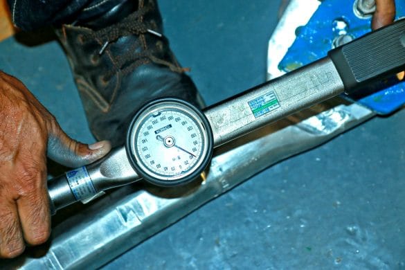 Man using torque wrench with dial to tighten bolt