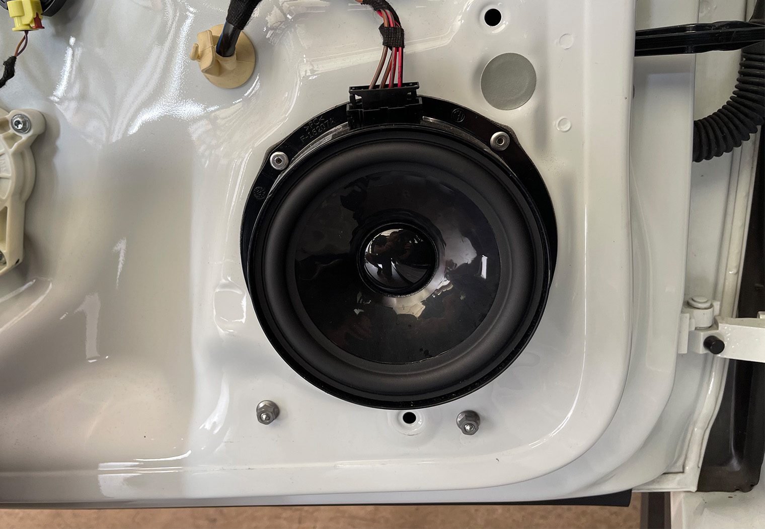Picture of the front driver side OEM Fender speaker before removing it from a Wolkswagen GTI MK7.5