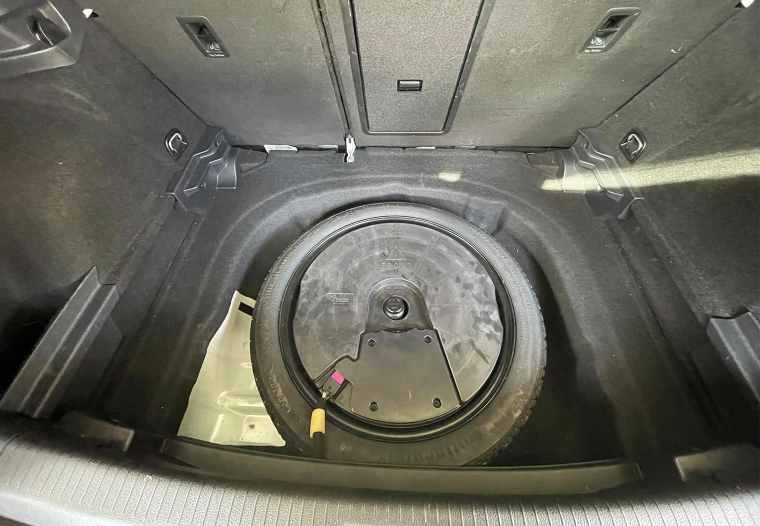 Picture of the OEM spare tire and Fender subwoofer in the trunk of VW GTI MK7.5