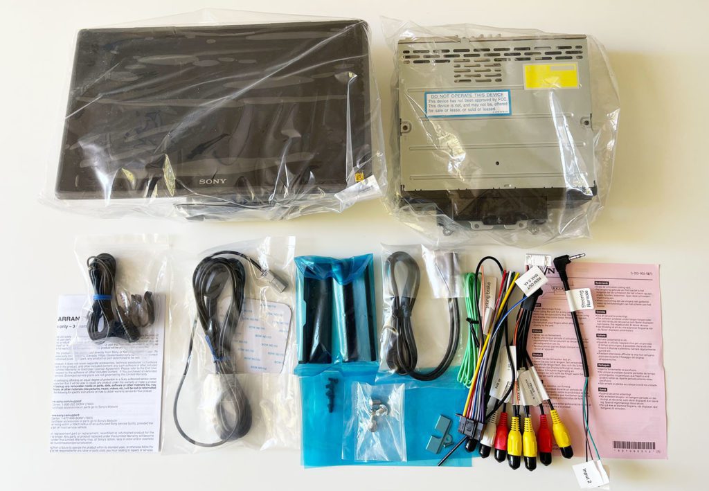 All of the contents laid out on a table to showcase all of the components that come in the box of the Sony XAV-9500ES