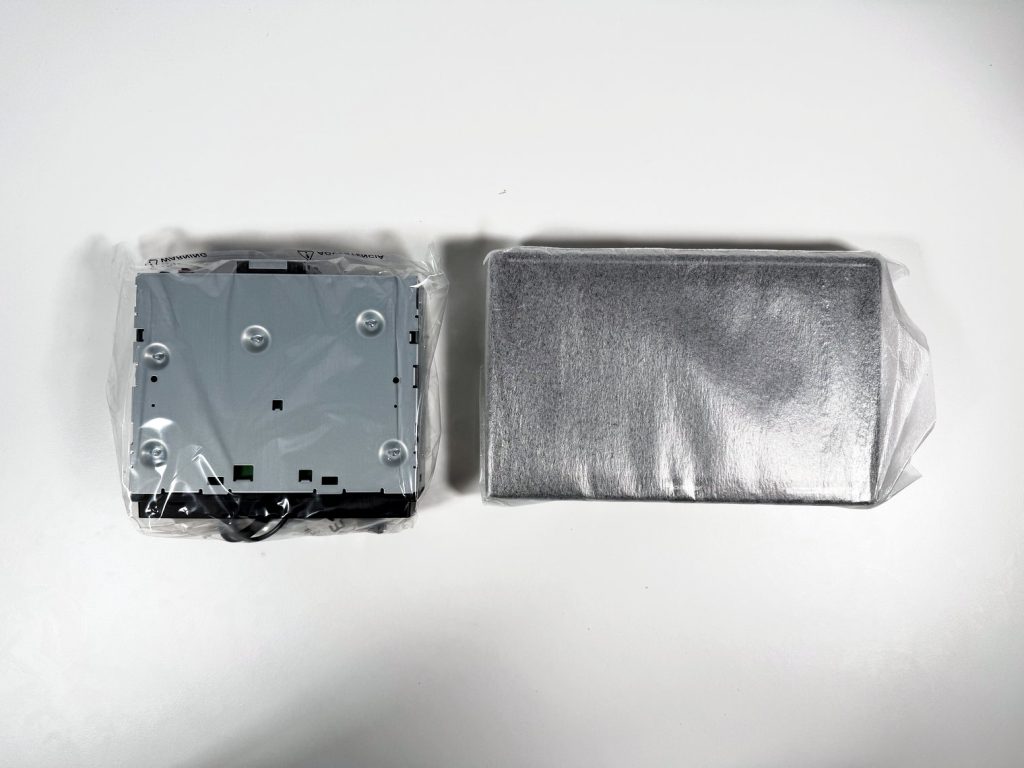 Pioneer DMH-WT8000NEX single-DIN chassis in its plastic bag beside the 10.1-inch monitor wrapped in foam