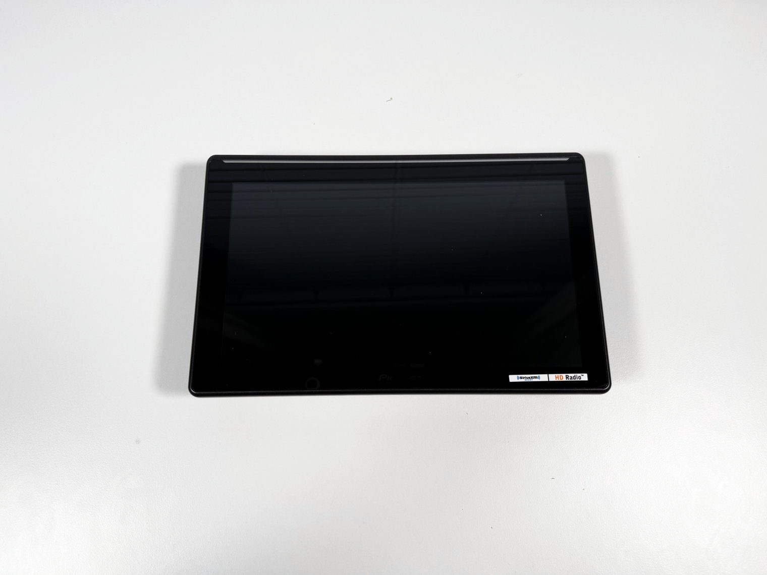 Pioneer DMH-WT8000NEX 10.1-inch monitor face up and powered off, shot straight down on a white table