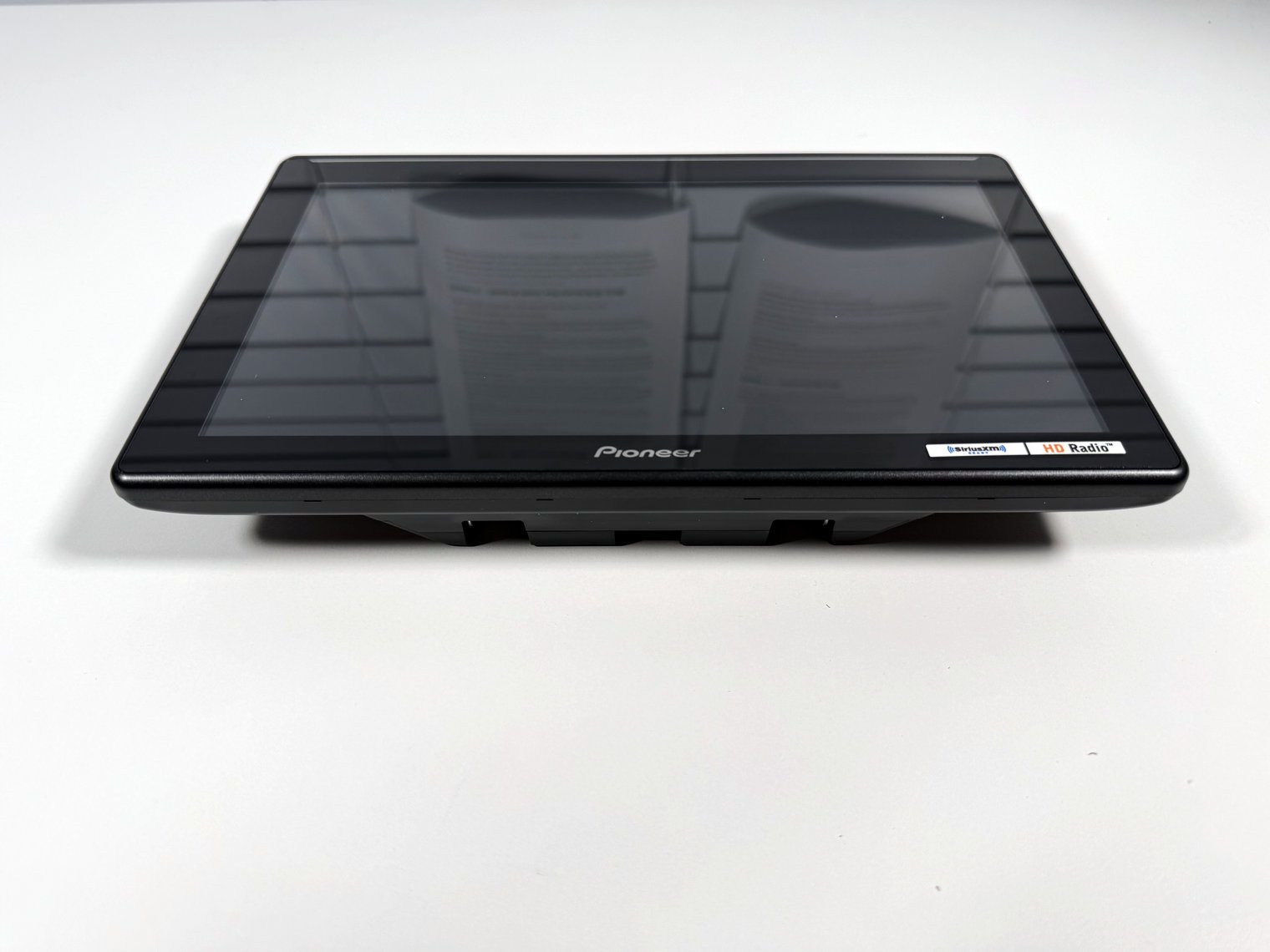 Pioneer DMH-WT8000NEX monitor from a low front angle, with paperwork reflecting in the glossy screen