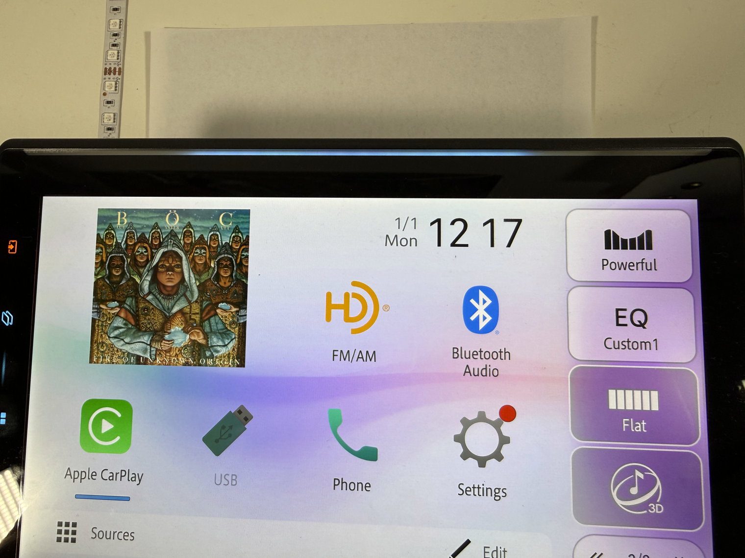 Close-up of the Pioneer DMH-WT8000NEX home screen with album art, FM/AM, Bluetooth Audio and Apple CarPlay icons