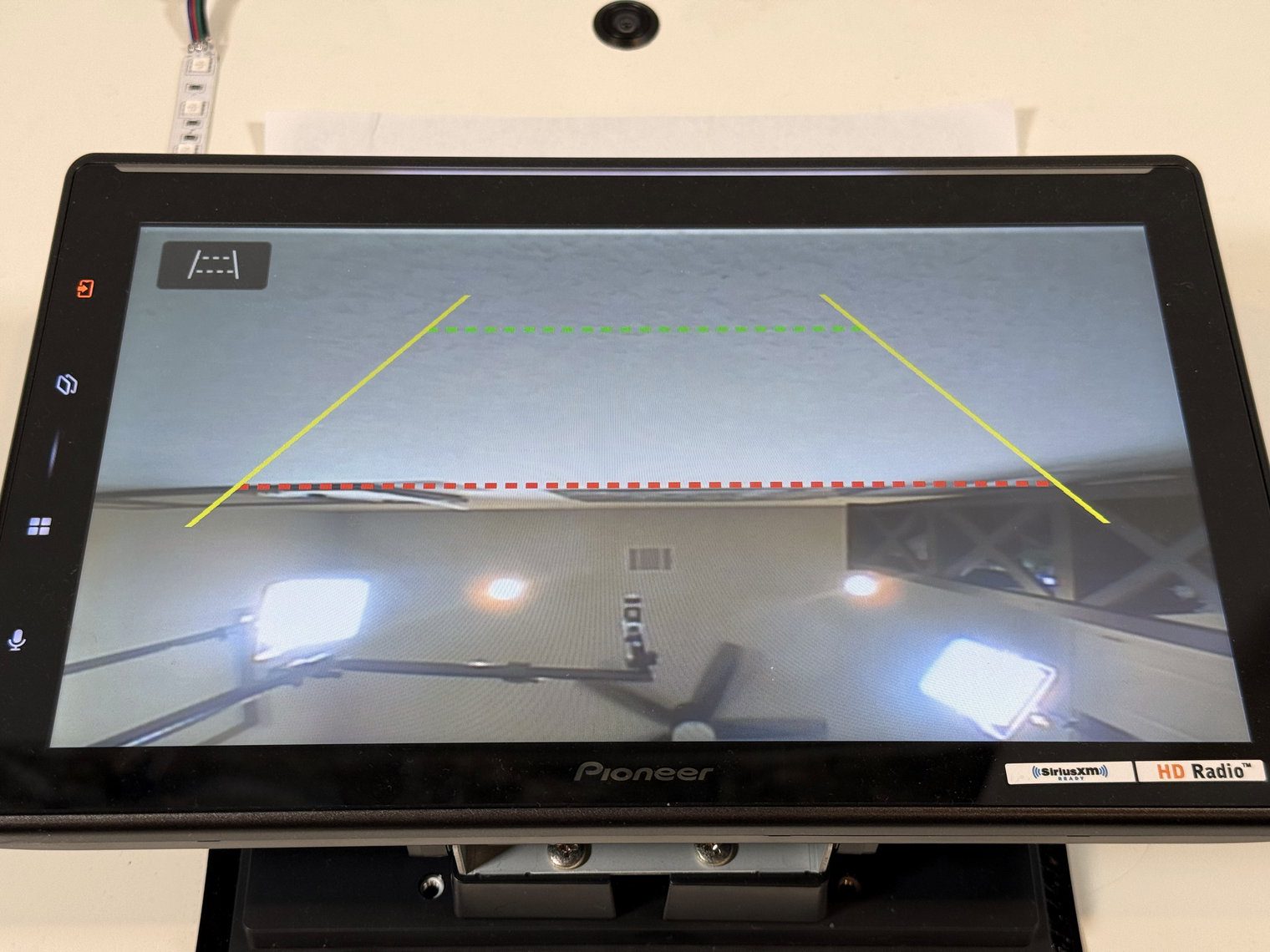 Pioneer DMH-WT8000NEX backup camera view with yellow, green and red parking guidelines over the live feed