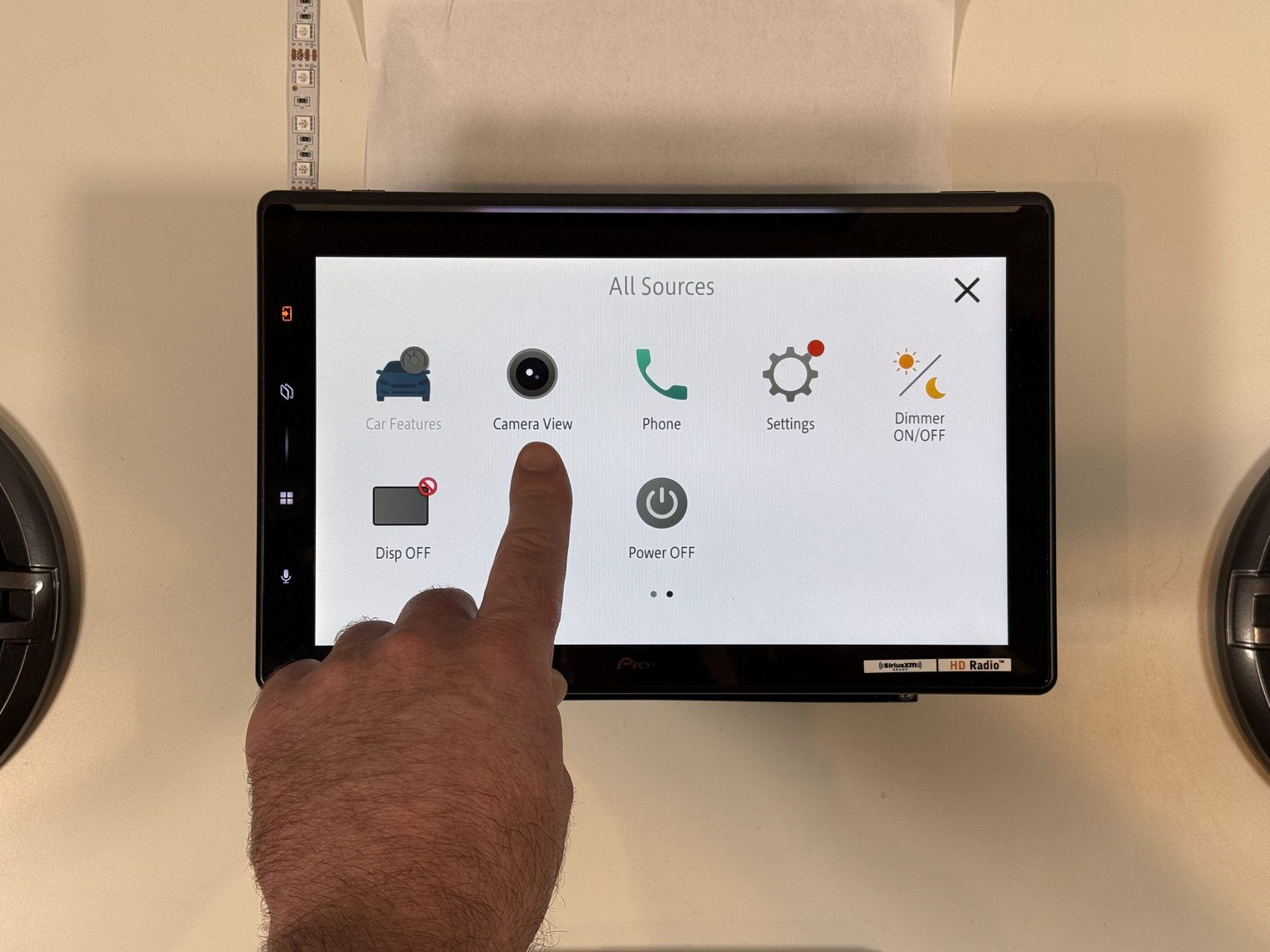 Pioneer DMH-WT8000NEX All Sources menu with a finger tapping the Camera View shortcut